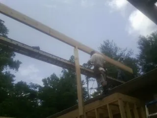Carpenter setting a ridge beam over a new addition frame — Ice Dam Removal by Roofing Brothers in Racine