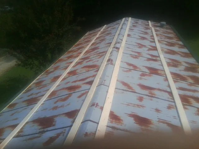 Rusted metal roof panels with new wood purlins before replacement — Storm Damage Roof Repair in Racine by Roofing Brothers