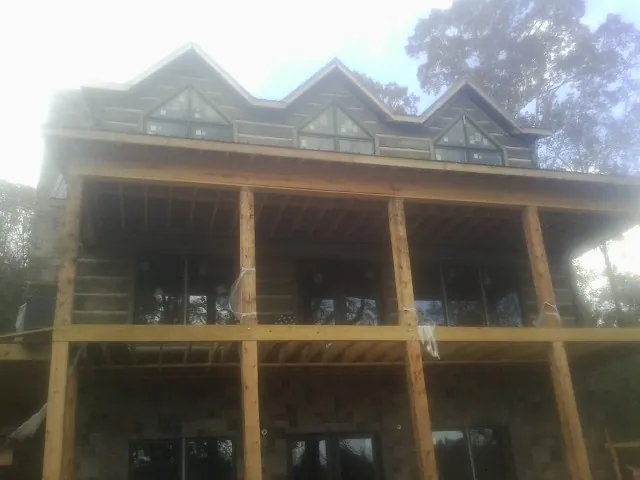 Dormers and porch framing on a large log home under construction in Racine