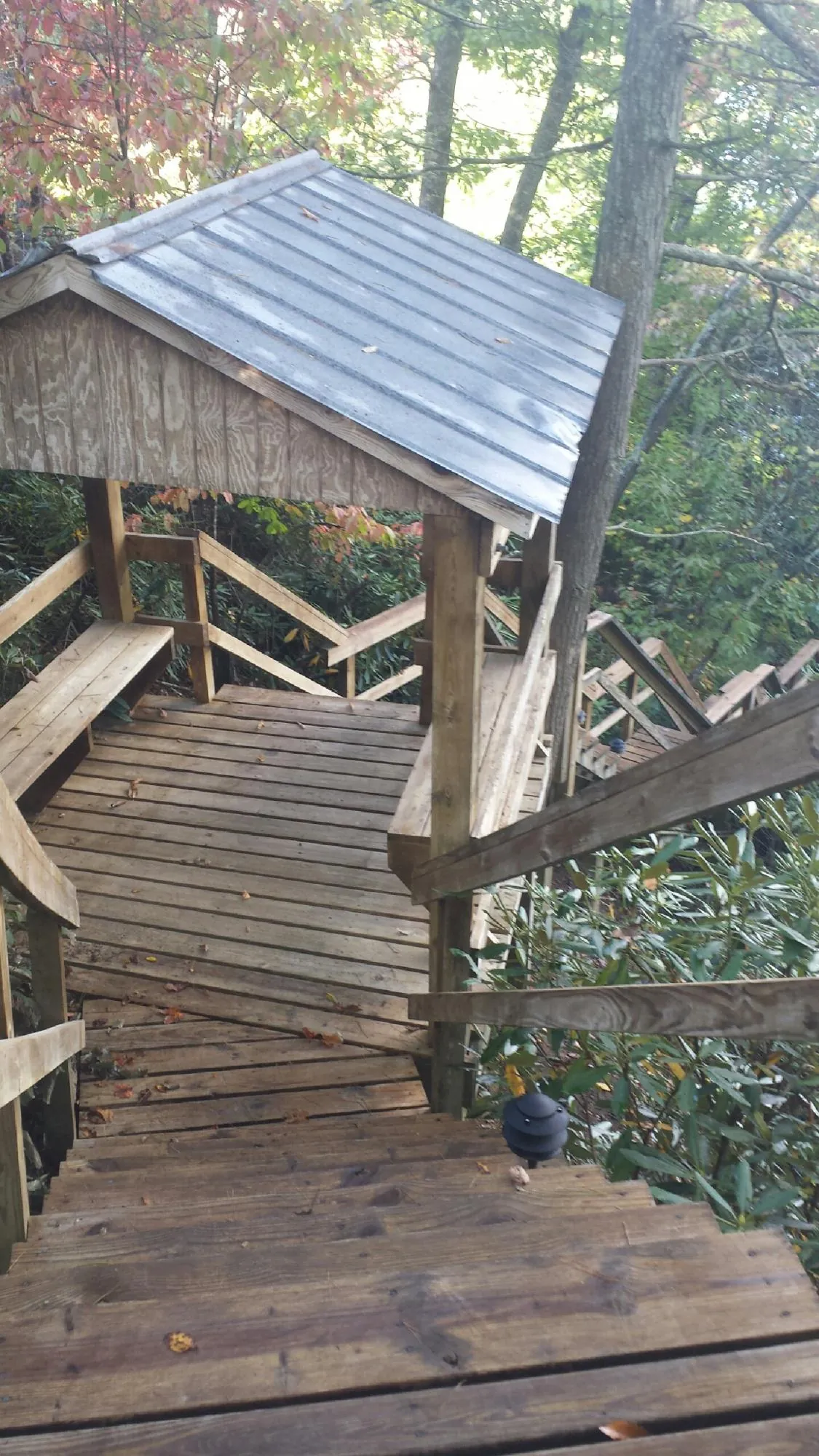 Metal roofed shelter over wooden steps on a wooded walkway — Skylight Repair & Installation work by our crew in Racine
